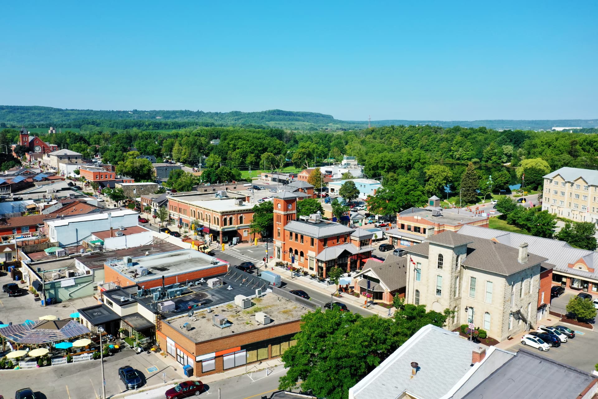 Aerial view of downtown Milton, Ontario, with its historic brick main street and the Niagara Escarpment beyond